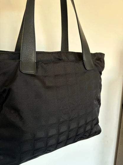 Chanel black shopping tote with woven CC jacquard pattern and smooth calfskin handles.