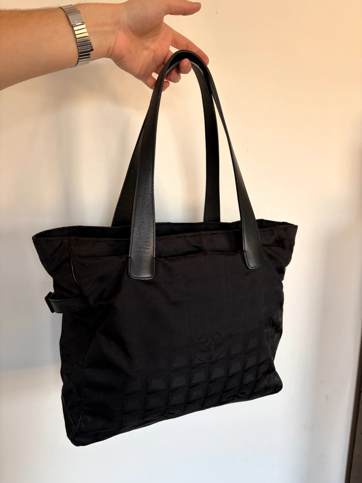 Chanel black shopping tote with woven CC jacquard pattern and smooth calfskin handles.