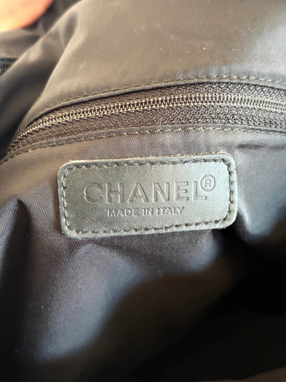 Chanel black shopping tote with woven CC jacquard pattern and smooth calfskin handles.