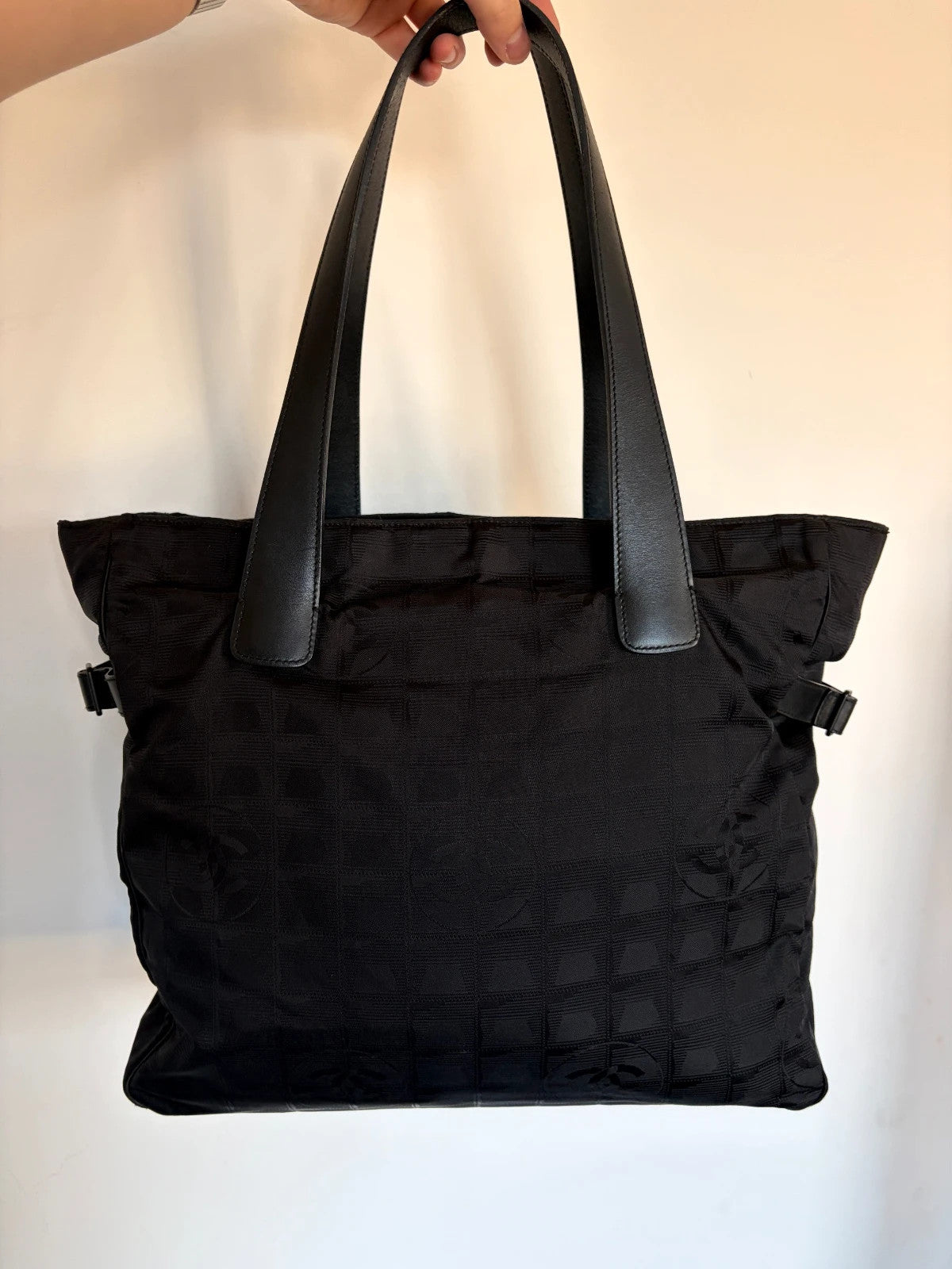Chanel black shopping tote with woven CC jacquard pattern and smooth calfskin handles.