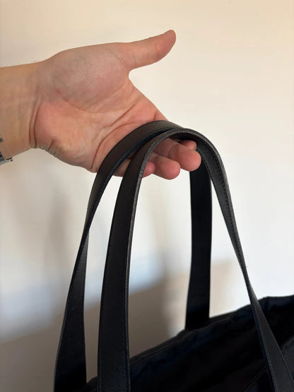 Chanel black shopping tote with woven CC jacquard pattern and smooth calfskin handles.