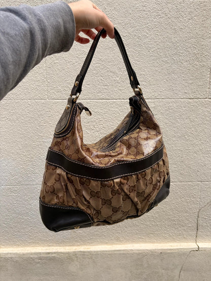 Gucci beige hobo bag with GG Crystal canvas, ruched design, and gold-tone hardware.