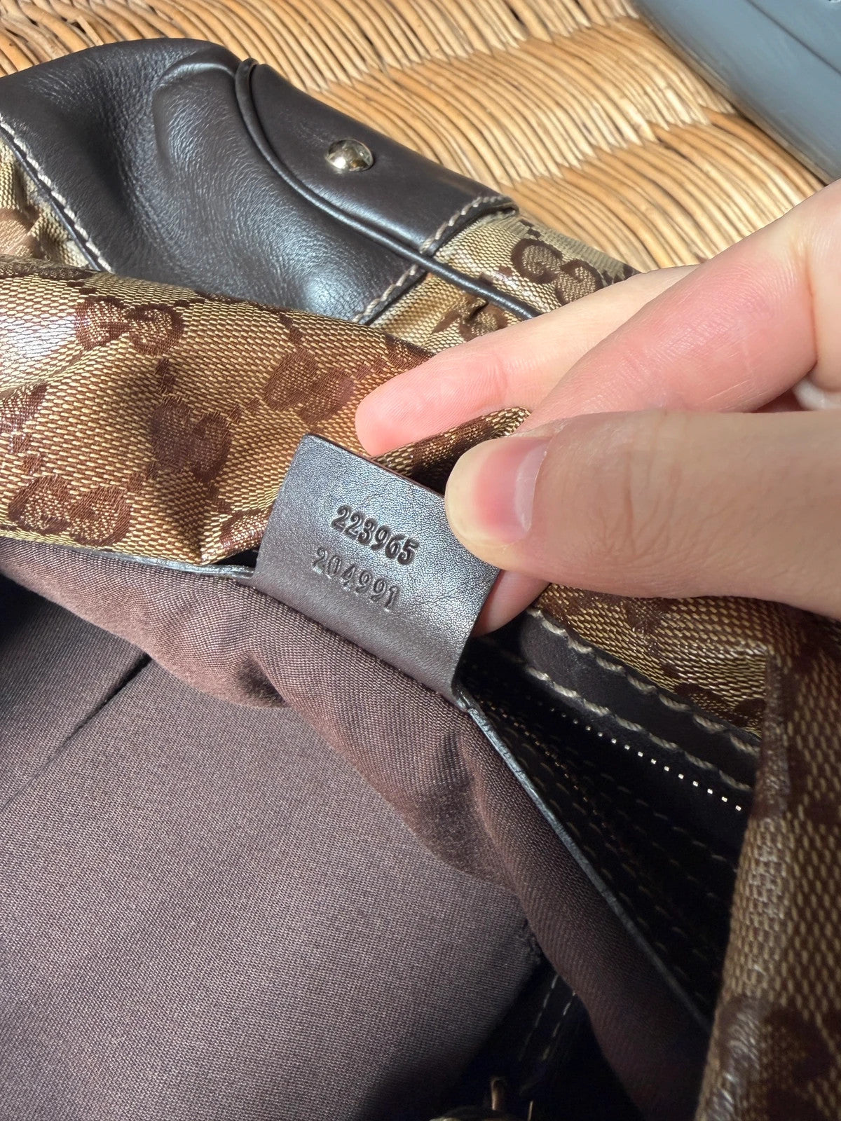 Gucci beige hobo bag with GG Crystal canvas, ruched design, and gold-tone hardware.