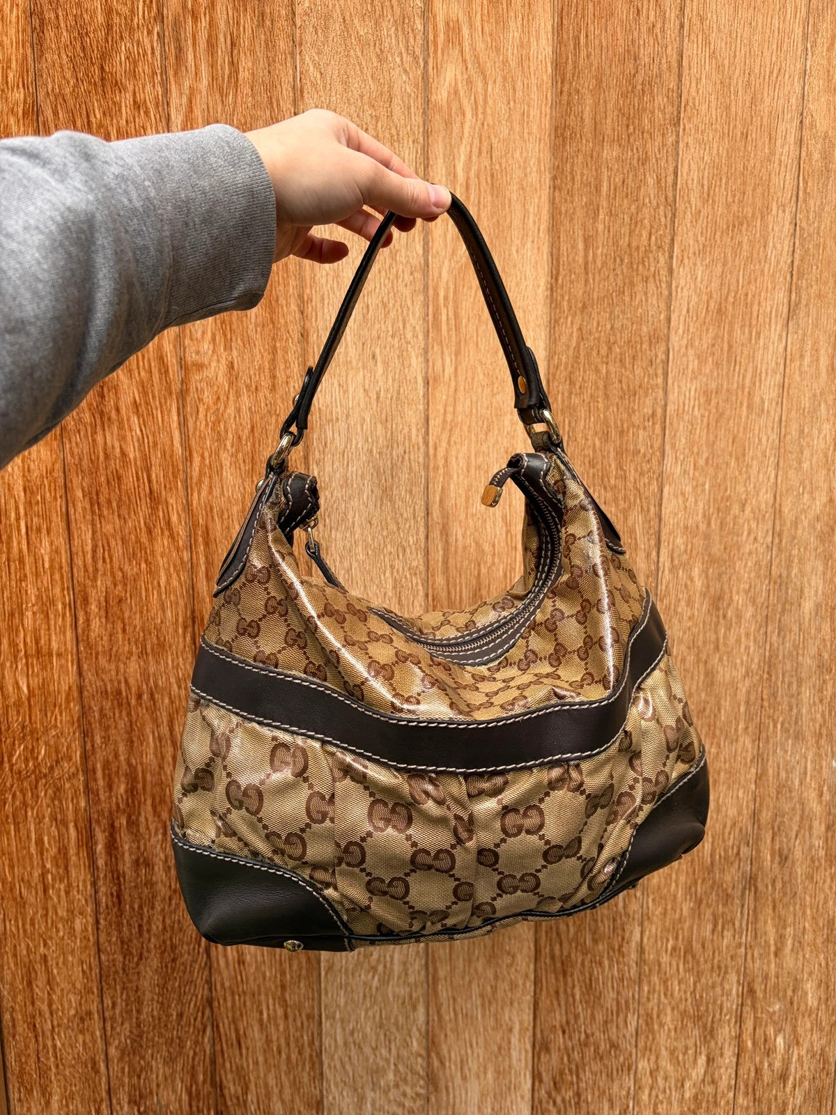 Gucci beige hobo bag with GG Crystal canvas, ruched design, and gold-tone hardware.