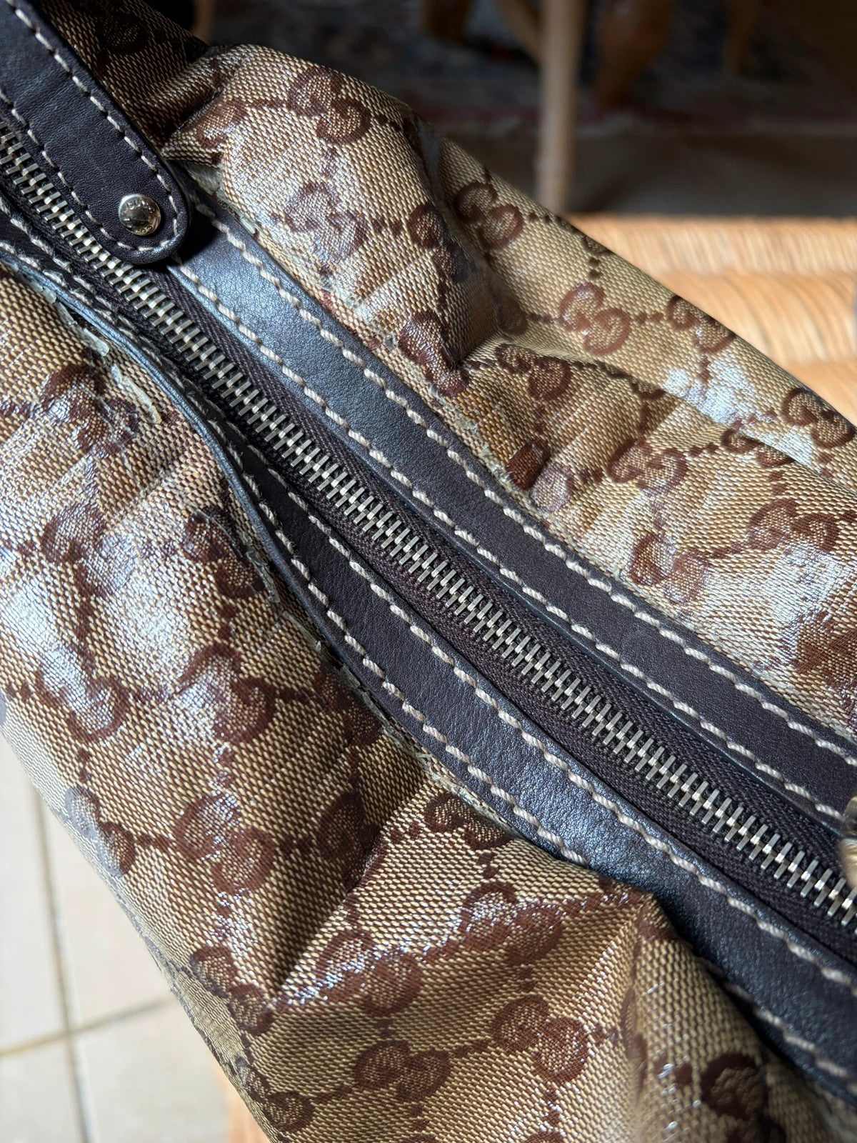 Gucci beige hobo bag with GG Crystal canvas, ruched design, and gold-tone hardware.