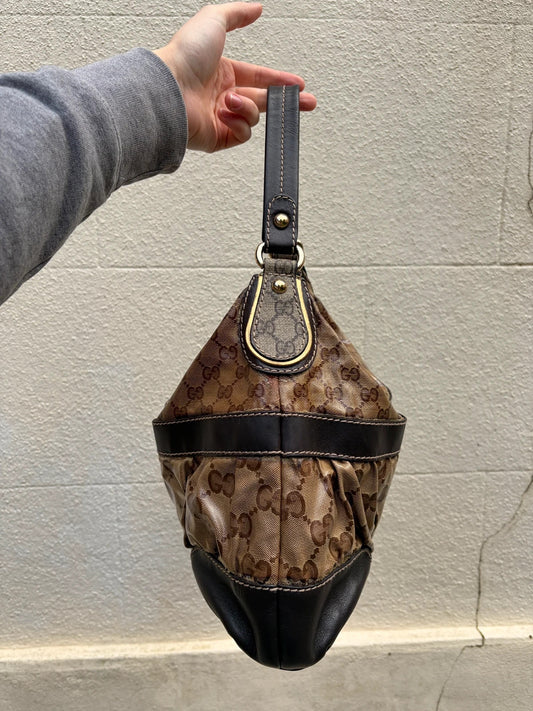 Gucci beige hobo bag with GG Crystal canvas, ruched design, and gold-tone hardware.