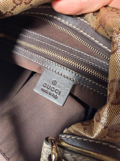 Gucci beige hobo bag with GG Crystal canvas, ruched design, and gold-tone hardware.