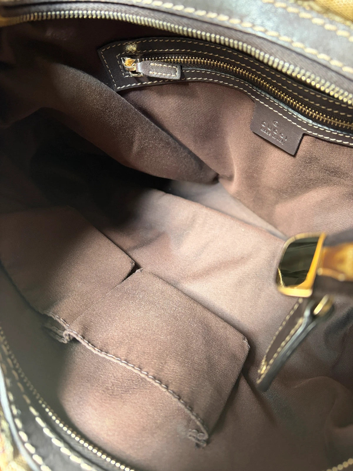 Gucci beige hobo bag with GG Crystal canvas, ruched design, and gold-tone hardware.