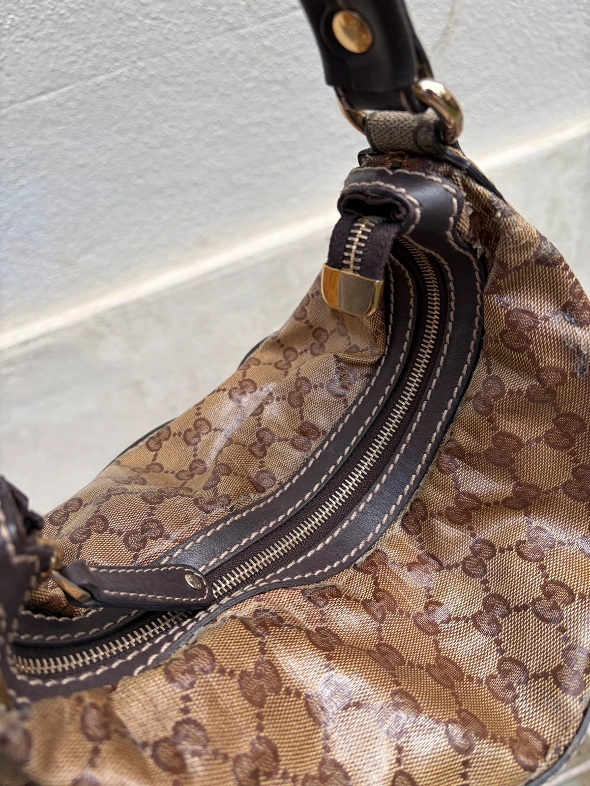Gucci beige hobo bag with GG Crystal canvas, ruched design, and gold-tone hardware.