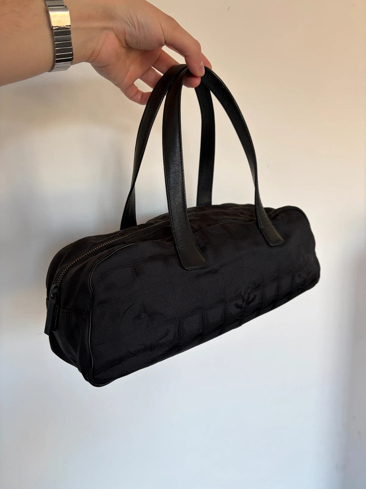 Chanel black handbag woven nylon jacquard with repeating CC monogram and leather trim.