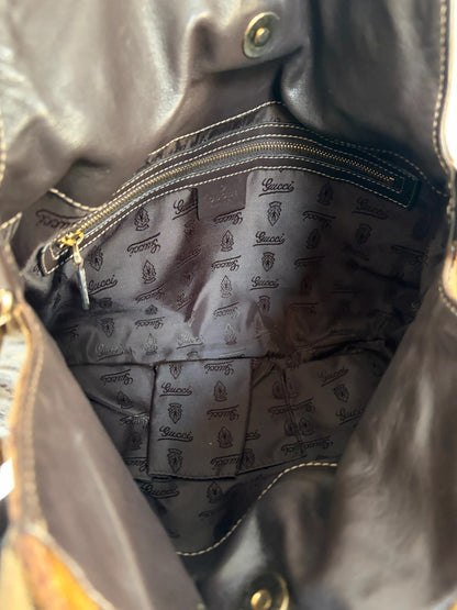 Gucci brown hobo bag with GG monogram, gold-tone knight crest medallions, and leather straps.