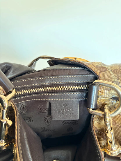 Gucci brown hobo bag with GG monogram, gold-tone knight crest medallions, and leather straps.