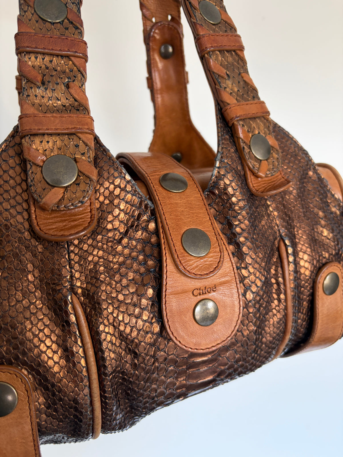 Chloé Silverado bag in metallic bronze python with whipstitched handles and studs