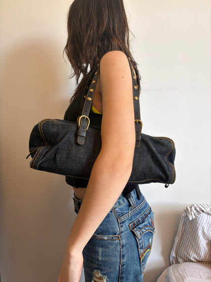 Person wearing a denim jacket and jeans against a plain background