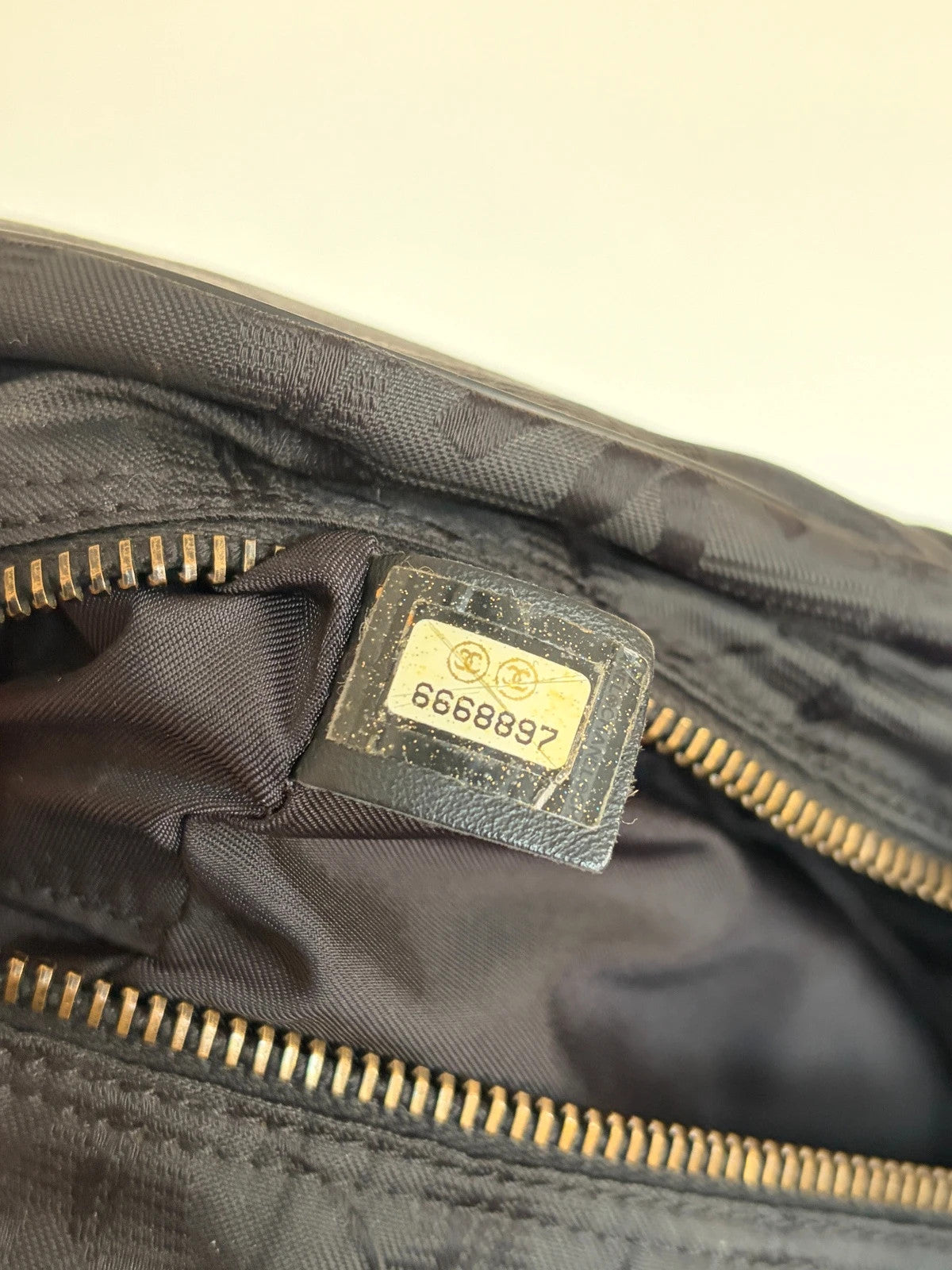 Chanel black handbag woven nylon jacquard with repeating CC monogram and leather trim.