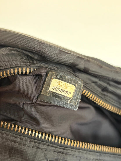 Chanel black handbag woven nylon jacquard with repeating CC monogram and leather trim.