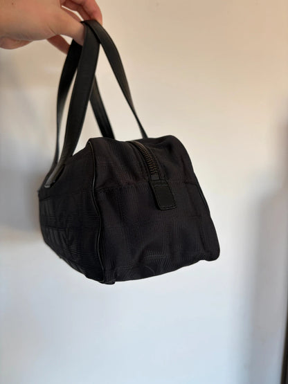 Chanel black handbag woven nylon jacquard with repeating CC monogram and leather trim.