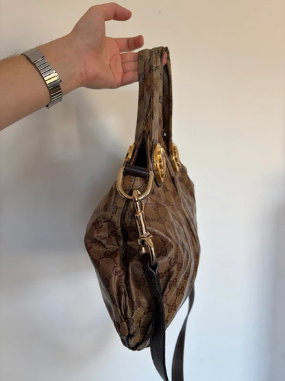 Gucci brown hobo bag with GG monogram, gold-tone knight crest medallions, and leather straps.