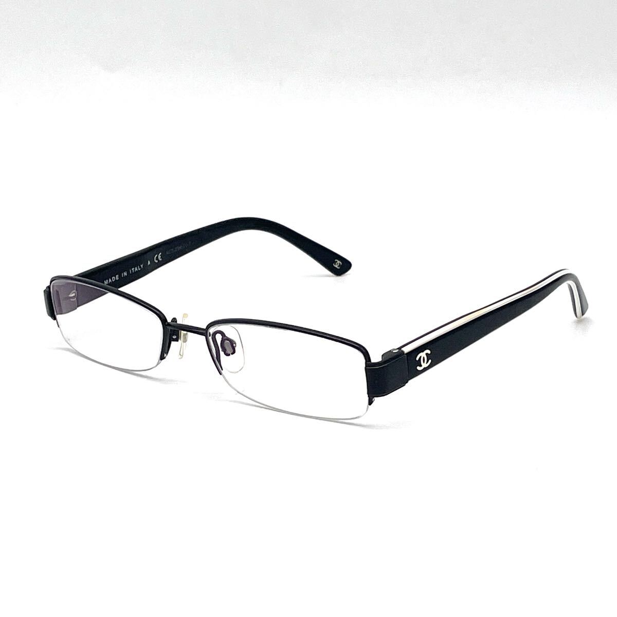 Chanel black rectangular rimless eyeglasses with white CC detailing and adjustable nose pads.
