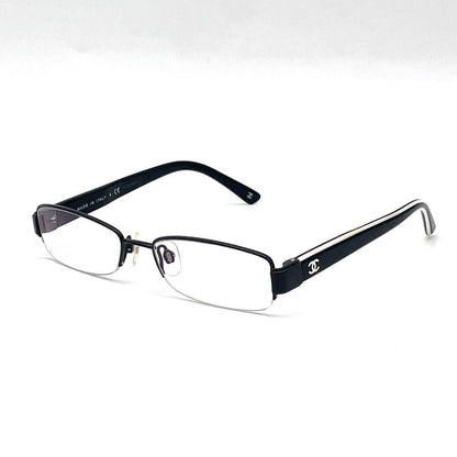 Chanel black rectangular rimless eyeglasses with white CC detailing and adjustable nose pads.