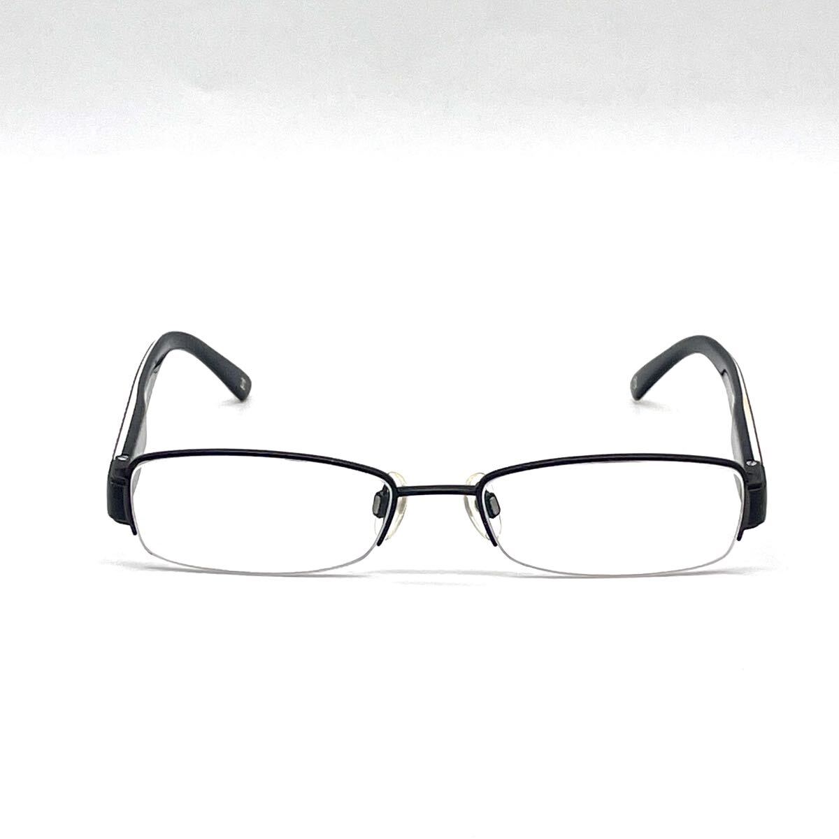 Chanel black rectangular rimless eyeglasses with white CC detailing and adjustable nose pads.