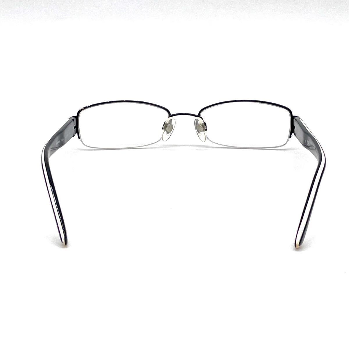 Chanel black rectangular rimless eyeglasses with white CC detailing and adjustable nose pads.