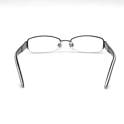 Chanel black rectangular rimless eyeglasses with white CC detailing and adjustable nose pads.