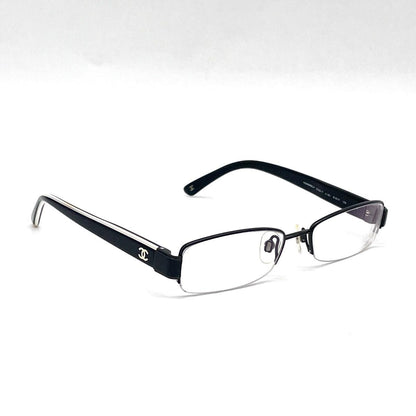 Chanel black rectangular rimless eyeglasses with white CC detailing and adjustable nose pads.