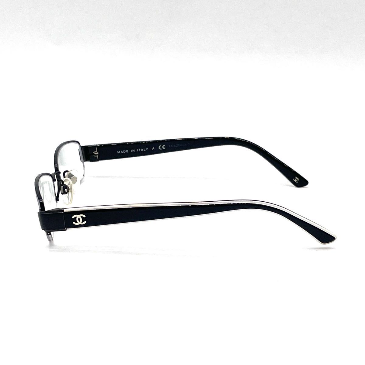Chanel black rectangular rimless eyeglasses with white CC detailing and adjustable nose pads.