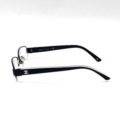 Chanel black rectangular rimless eyeglasses with white CC detailing and adjustable nose pads.