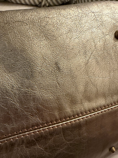 Chloé beige metallic handbag with oversized brass padlock and dual rolled handles.