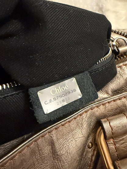 Chloé beige metallic handbag with oversized brass padlock and dual rolled handles.